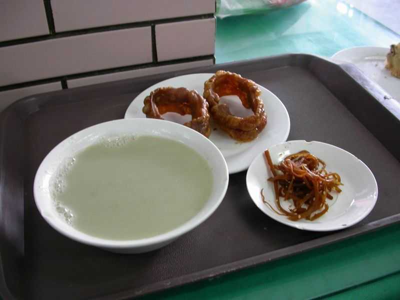 A bowl of douzhi (left) with jiaoquan and preserved vegetable (Wikipedia)